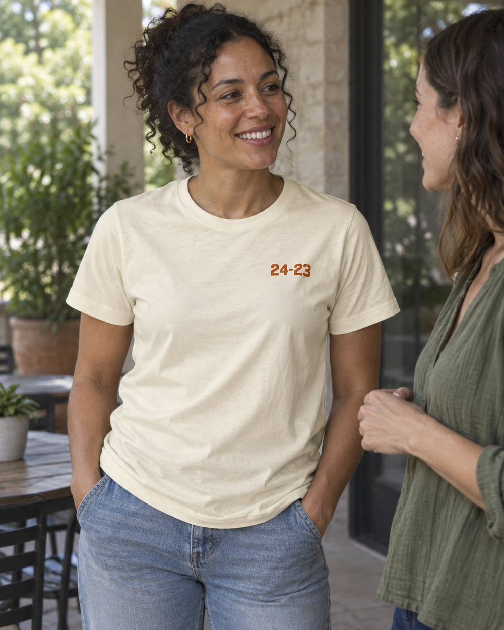 Woman wearing the unisex scoreboard tee, showing the small front score